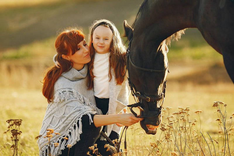 Image of mother and daughter playing with horse